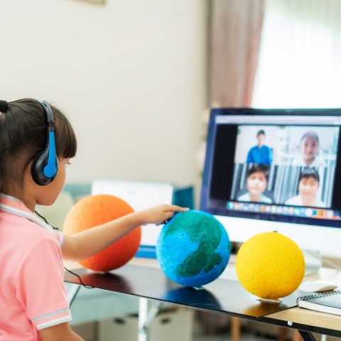 Asian girl student live learning video conference with teacher a Asian girl student live learning video conference with teacher and other classmates giving presentation, showing solar model project, Homeschooling and distance learning ,online ,education and internet.